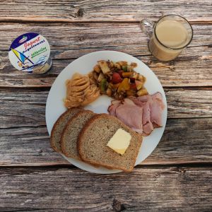 Zdjęcie przedstawia Dietę z ograniczeniem łatwoprzyswajalnych węglowodan&oacute;w: Chleb Graham Masło extra Sałatka owocowa ze słonecznikiem Schab Kruchy z Liszek Kawa zbożowa z mlekiem Jogurt naturalny Pasta z grochu